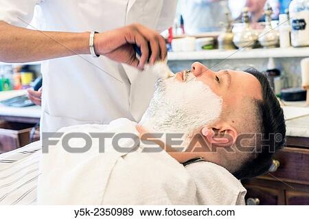 Rotterdam, Netherlands. Barber store Schorem. Male customer lying back in his barber chair while receiving a wet shave. View Large Photo Image Stock Photo - Rotterdam, Netherlands. Barber store Schorem. Male customer lying back in his barber chair while receiving a wet shave.. Fotosearch