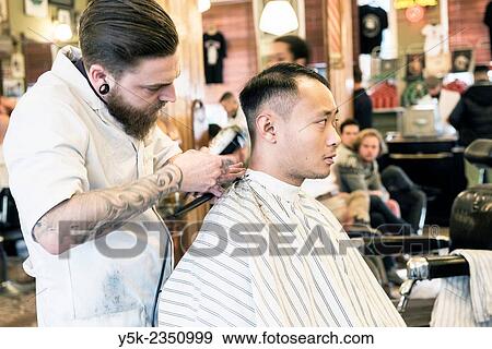 Rotterdam, Netherlands. Barber store Schorem. Barber helping his customer in his barber shop by cutting and modeling his hair. View Large Photo Image Stock Photo - Rotterdam, Netherlands. Barber store Schorem. Barber helping his customer in his barber shop by cutting and modeling his hair.. Fotosearch