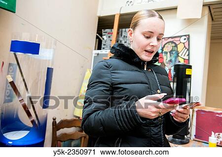 Rotterdam, Netherlands. Beautiful young, blonde woman reading messages on het pink colored smartphone, while making sounds of joy. View Large Photo Image Stock Image - Rotterdam, Netherlands. Beautiful young, blonde woman reading messages on het pink colored smartphone, while making sounds of joy.. Fotosearch