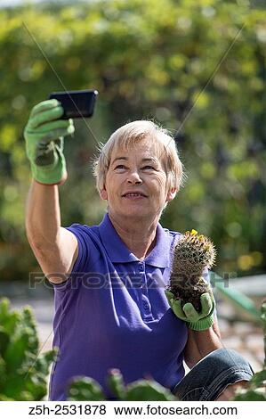 Russian Federation. A pensioner in the garden with the phone. View Large Photo Image Stock Photo - Russian Federation. A pensioner in the garden with the phone.. Fotosearch