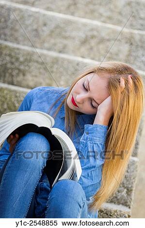 Stock Photography - Schoolgirl reading heavy book.. Fotosearch
