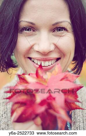 Stock Image - Smiling mid adult woman portrait, autumn. Fotosearch