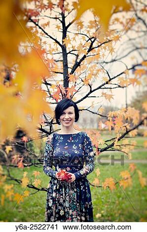 Stock Image - Smiling mid adult woman portrait, autumn. Fotosearch