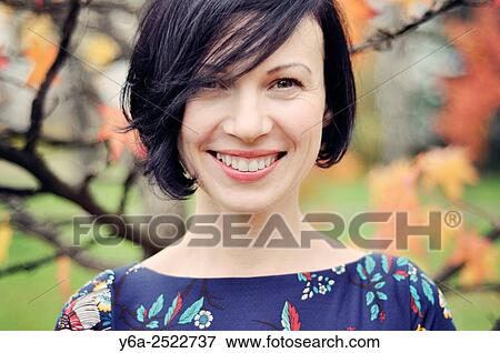 Stock Photo - Smiling mid adult woman portrait, autumn. Fotosearch