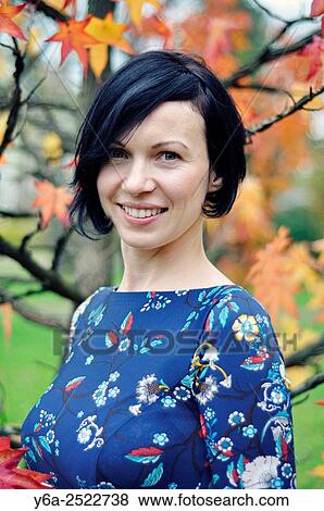 Stock Photo - Smiling mid adult woman portrait, autumn. Fotosearch