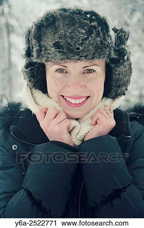 Stock Image - Smiling mid adult woman portrait, winter. Fotosearch
