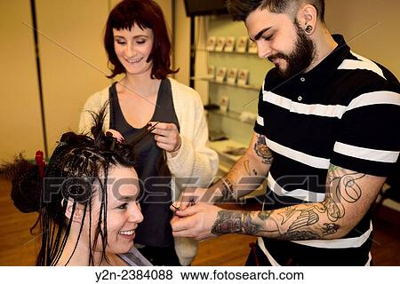 Smiling young male and female trainee hairstylists working on braiding hair of a model in a salon. View Large Photo Image Stock Photo - Smiling young male and female trainee hairstylists working on braiding hair of a model in a salon.. Fotosearch