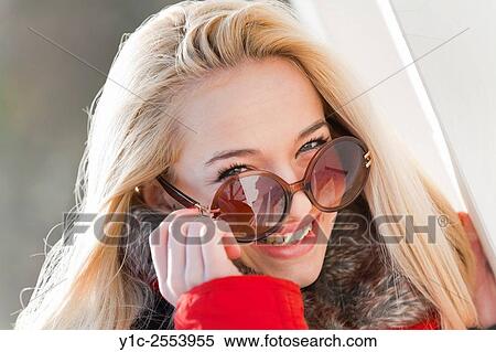 Stock Photography - Teenager girl portrait peeking over glasses. Fotosearch
