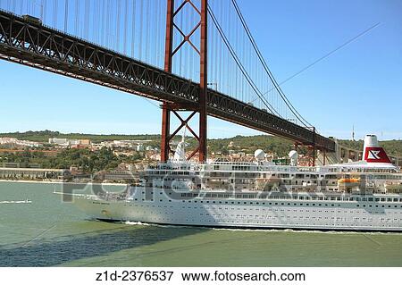 Stock Photo - the Black Watch passenger liner sailing from Lisbon Portugal up the Tagus estuary, passing under the 25th April bridge.. Fotosearch