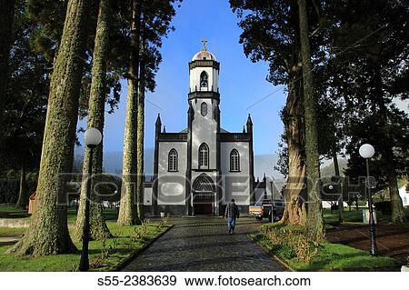 The front facade and alleyway to the Church of Saint Nicholas. Church of Sao Nicolau (Portuguese: Igreja Paroquial de Sete Cidades/Igreja de S? o Nicolau), the revivalist Neo-Gothic church. Sete Cidades, Sao Miguel island, Azores, Portugal. View Large Photo Image Stock Photo - The front facade and alleyway to the Church of Saint Nicholas. Church of Sao Nicolau (Portuguese: Igreja Paroquial de Sete Cidades/Igreja de S? o Nicolau), the revivalist Neo-Gothic church. Sete Cidades, Sao Miguel island, Azores, Portugal.. Fotosearch