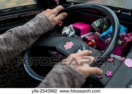 Stock Image - The Hague, Netherlands. Two hands on the steering wheel of a small, motorized vehicle.. Fotosearch