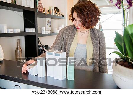 Tilburg, Netherlands. Portrait of a young, attractive woman, choosing make up products after her session in a beauty salon. View Large Photo Image Stock Photo - Tilburg, Netherlands. Portrait of a young, attractive woman, choosing make up products after her session in a beauty salon.. Fotosearch