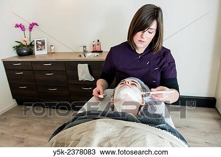 Tilburg, Netherlands. Young beautician applying cleansing cream to the facial skin of her customer. View Large Photo Image Stock Image - Tilburg, Netherlands. Young beautician applying cleansing cream to the facial skin of her customer.. Fotosearch