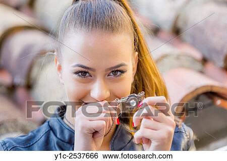 Stock Photograph - Tiny model camera and teen portrait.. Fotosearch