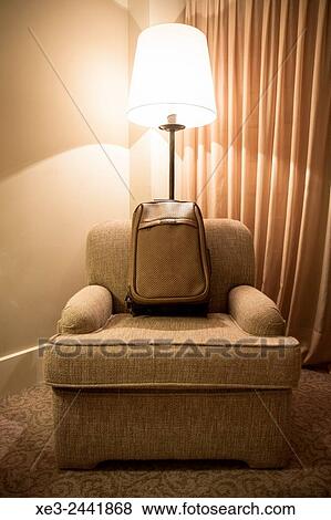 Stock Photo - Trolley case on armchair. Fotosearch