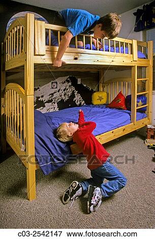 Stock Photo - Two brothers play on their bunk beds at home in Corona, CA. MODEL RELEASE.. Fotosearch