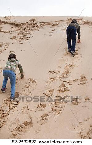 Stock Image - two children up sand dune. Fotosearch