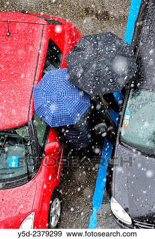 two persons under umbrellas in heavy snowfall trying to get into the car in parking lot, Geneva, Switzerland. View Large Photo Image Stock Photo - two persons under umbrellas in heavy snowfall trying to get into the car in parking lot, Geneva, Switzerland.. Fotosearch