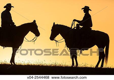 Two wranglers (cowboys) on horses at sunset, California, USA View Large Photo Image Stock Photo - Two wranglers (cowboys) on horses at sunset, California, USA. Fotosearch