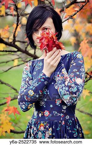 Woman holding leaves close to her face, autumn View Large Photo Image Stock Photography - Woman holding leaves close to her face, autumn. Fotosearch