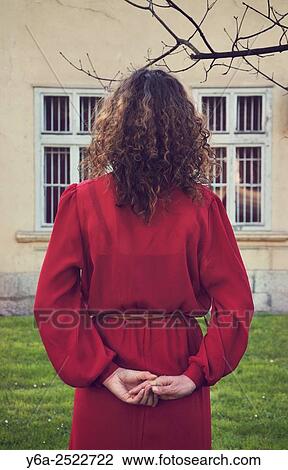 Woman in red dress standing outdoors, rear view. View Large Photo Image Stock Image - Woman in red dress standing outdoors, rear view.. Fotosearch
