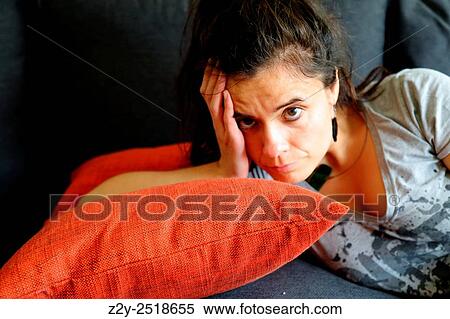 Woman on a pillow holding her head and looking at the camera. View Large Photo Image Stock Photography - Woman on a pillow holding her head and looking at the camera.. Fotosearch