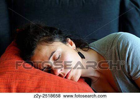 Stock Photo - Woman sleeping on an orange pillow.. Fotosearch