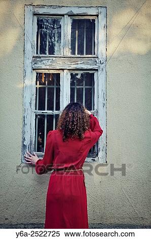 Woman standing outside the house looking through window. View Large Photo Image Stock Photography - Woman standing outside the house looking through window.. Fotosearch