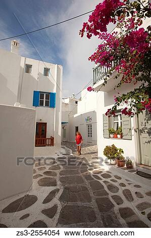 Picture - Woman walking in the alleys of town center, Mykonos, Cyclades Islands, Greek Islands, Greece, Europe.. Fotosearch