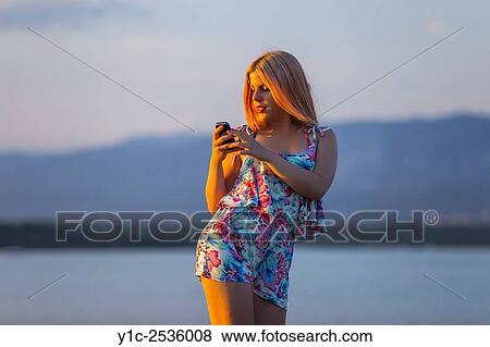 Stock Photo - Writing sms message on beach.. Fotosearch