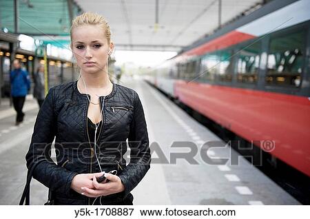 Young, blonde female, on the platform of a railway-station, waiting for her train. View Large Photo Image Stock Photo - Young, blonde female, on the platform of a railway-station, waiting for her train.. Fotosearch