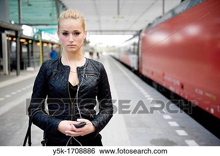Young, blonde female, on the platform of a railway-station, waiting for her train. View Large Photo Image Stock Photograph - Young, blonde female, on the platform of a railway-station, waiting for her train.. Fotosearch