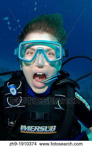 Picture - Young diver having mouth cleaned by cleanerfish, Sabre-toothed blenny Aspidontus taeniatus, Red Sea, Egypt, Africa. Fotosearch