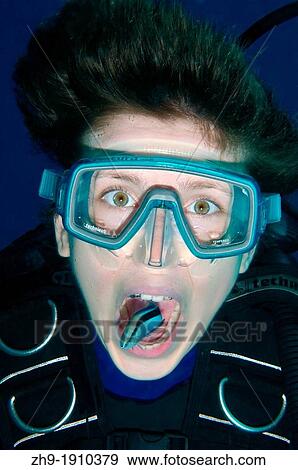 Stock Photo - Young diver having mouth cleaned by cleanerfish, Sabre-toothed blenny Aspidontus taeniatus, Red Sea, Egypt, Africa. Fotosearch