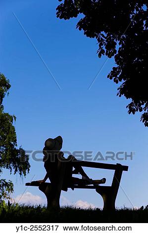 Young female on bench silhouetting against Blue sky View Large Photo Image Stock Photo - Young female on bench silhouetting against Blue sky. Fotosearch