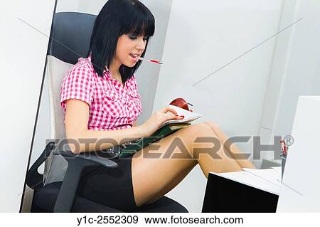 Young female secretary in office browsing papers View Large Photo Image Stock Photo - Young female secretary in office browsing papers. Fotosearch