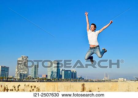 Young man jumping against city skyline. Barcelona, Catalonia, Spain. View Large Photo Image Stock Image - Young man jumping against city skyline. Barcelona, Catalonia, Spain.. Fotosearch