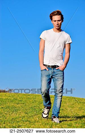 Young man walking on the green grass. View Large Photo Image Stock Photo - Young man walking on the green grass.. Fotosearch