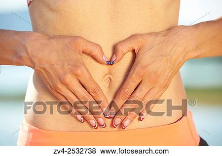 Stock Photo - Young woman doing yoga on a beach next to a little lake.. Fotosearch