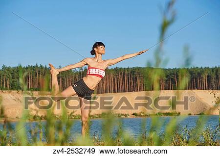 Young woman doing yoga on a beach next to a little lake. View Large Photo Image Stock Photo - Young woman doing yoga on a beach next to a little lake.. Fotosearch