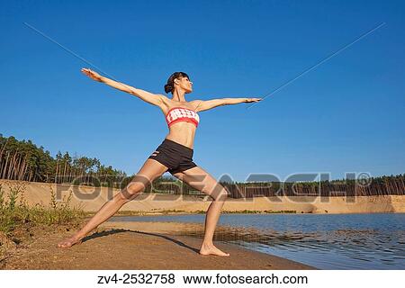 Young woman doing yoga on a beach next to a little lake. View Large Photo Image Stock Photo - Young woman doing yoga on a beach next to a little lake.. Fotosearch