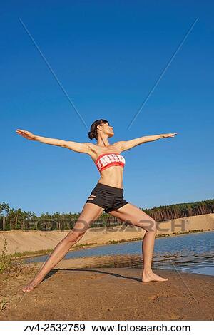 Young woman doing yoga on a beach next to a little lake. View Large Photo Image Stock Photo - Young woman doing yoga on a beach next to a little lake.. Fotosearch