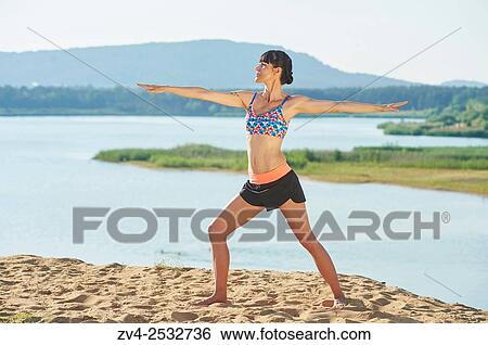 Young woman doing yoga on a beach next to a little lake. View Large Photo Image Stock Photograph - Young woman doing yoga on a beach next to a little lake.. Fotosearch