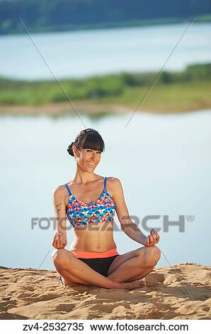 Young woman doing yoga on a beach next to a little lake. View Large Photo Image Stock Photography - Young woman doing yoga on a beach next to a little lake.. Fotosearch