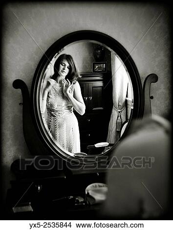 Young woman dressing in front of a vanity mirror. View Large Photo Image Picture - Young woman dressing in front of a vanity mirror.. Fotosearch