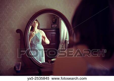Young woman dressing in front of a vanity mirror. View Large Photo Image Stock Photography - Young woman dressing in front of a vanity mirror.. Fotosearch