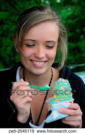 Young woman eating an ice cream in Ystad, Sweden. View Large Photo Image Stock Photo - Young woman eating an ice cream in Ystad, Sweden.. Fotosearch
