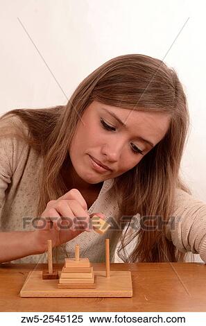 Stock Photography - Young woman play Towers-of-Hanoi.. Fotosearch