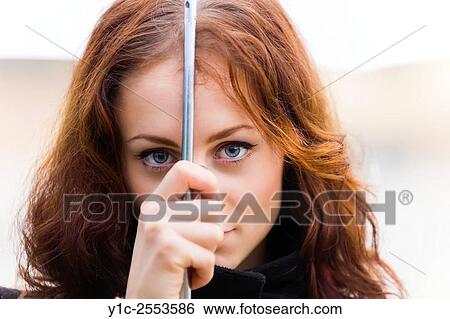 Stock Photograph - Young woman portrait under umbrella on rainy day. Fotosearch