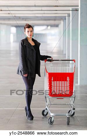 Stock Photograph - Young woman shopper with empty cart. Fotosearch